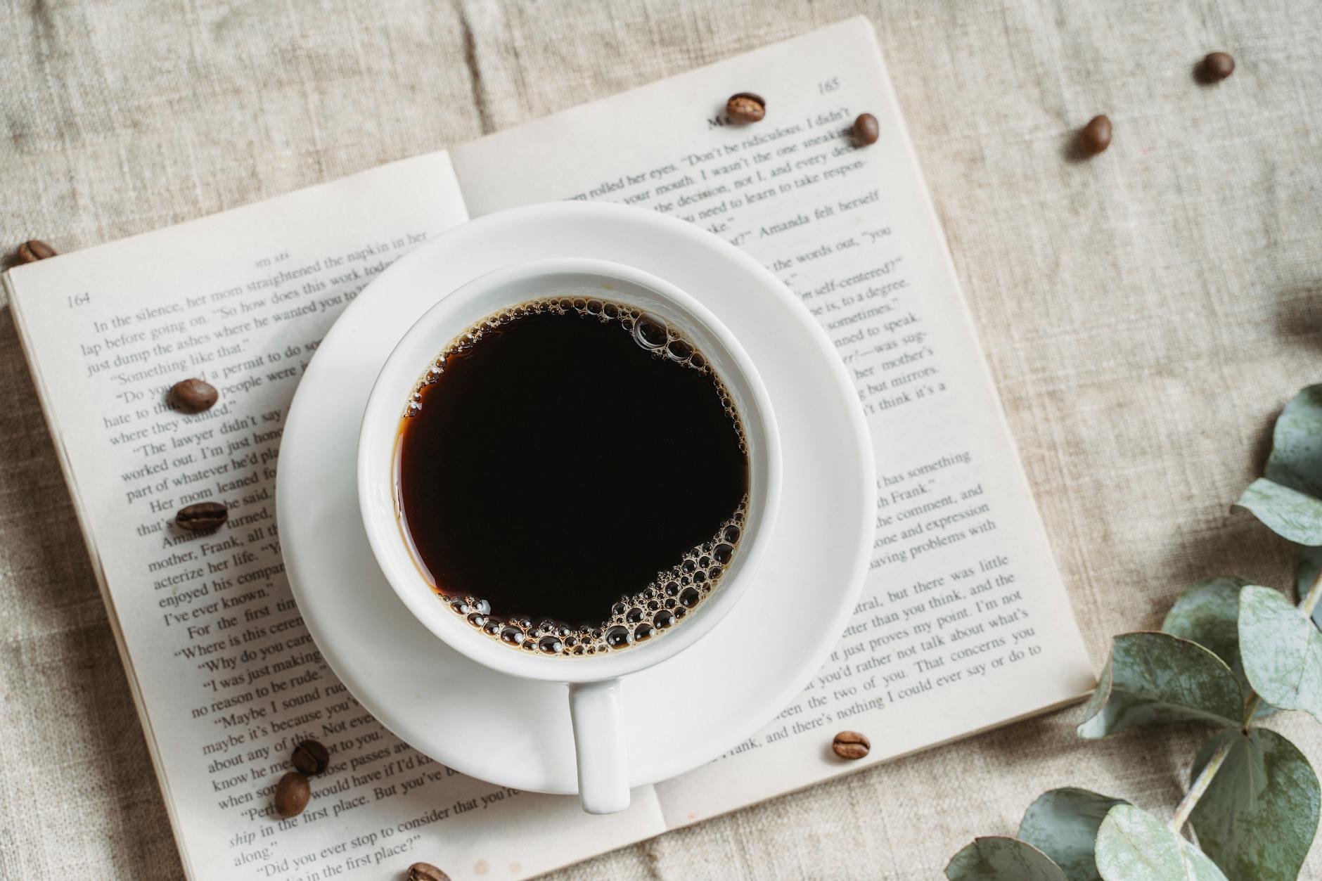 فنجان قهوة مع كتاب لتطوير العادات اليومية وتحفيز الذات
